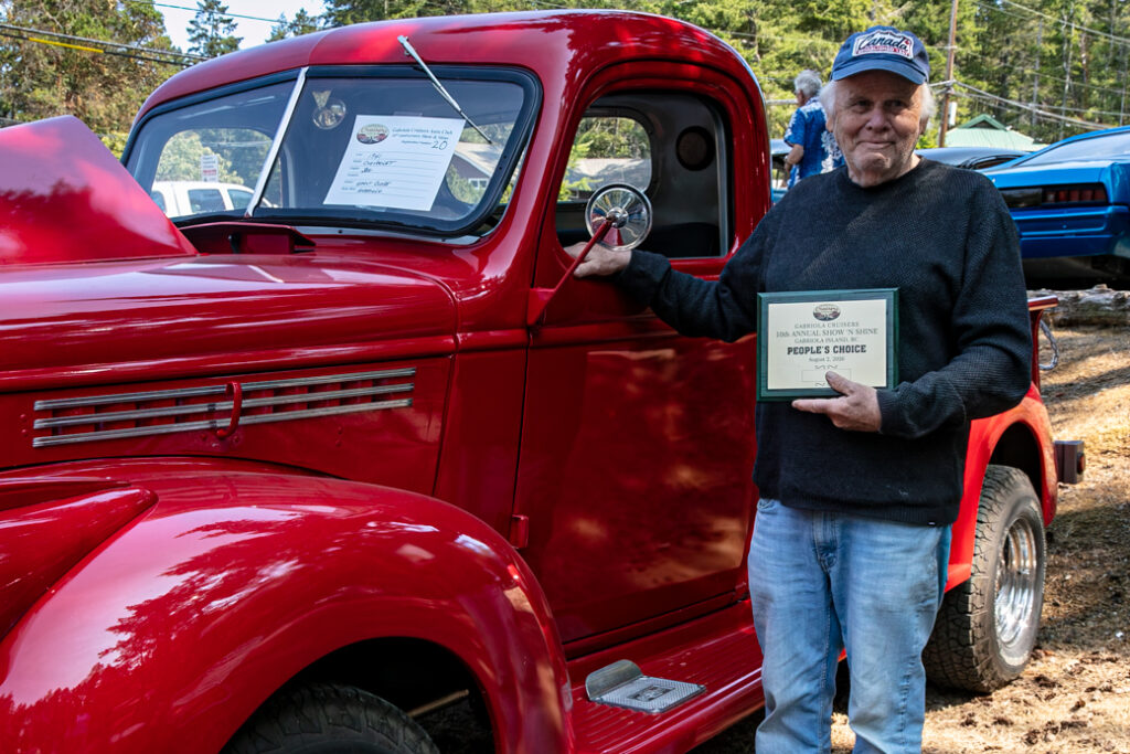 Grant Close standing beside his red Chevy pickup truck.